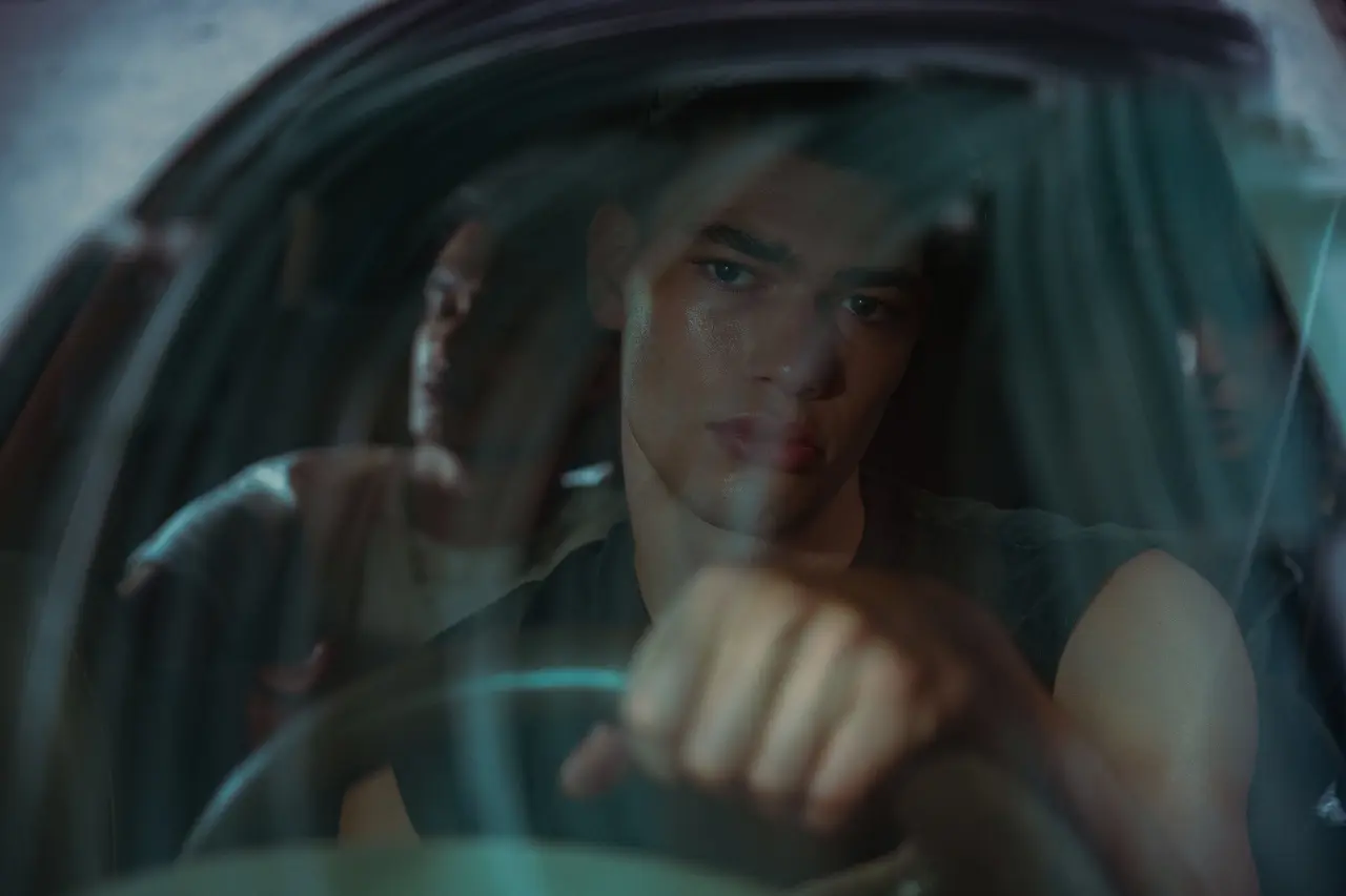 Driver viewed through a curved windshield