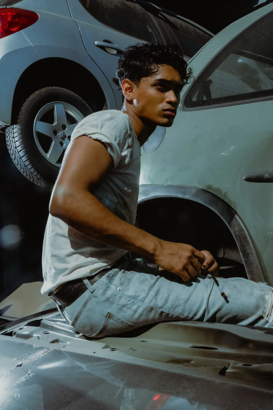 Mechanic holding a wrench beside a vehicle